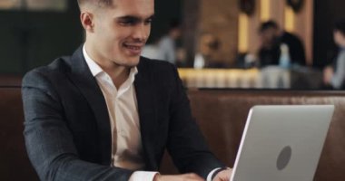 Kafeterya masada oturan dizüstü bilgisayar kullanan gülümseyen iş adamı