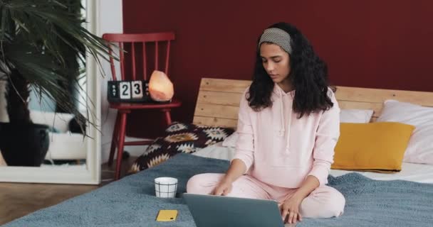 Hermosa joven afroamericana mujer haciendo ejercicio de yoga y viendo lección de tutorial en el ordenador portátil en casa — Vídeos de Stock