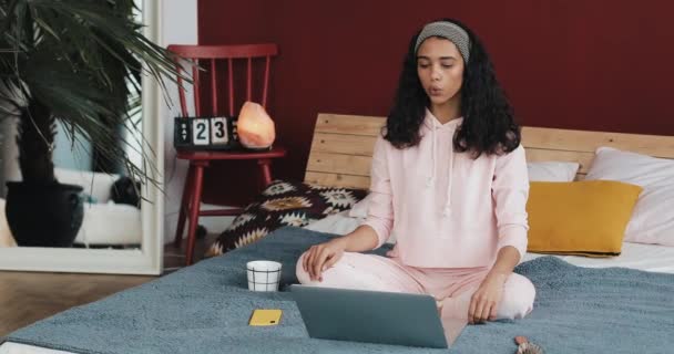 아름 다운 젊은 아프리카계 미국인 여자 요가 운동을 하 고 집에서 노트북 컴퓨터에 튜토리얼 수업을 보고 — 비디오