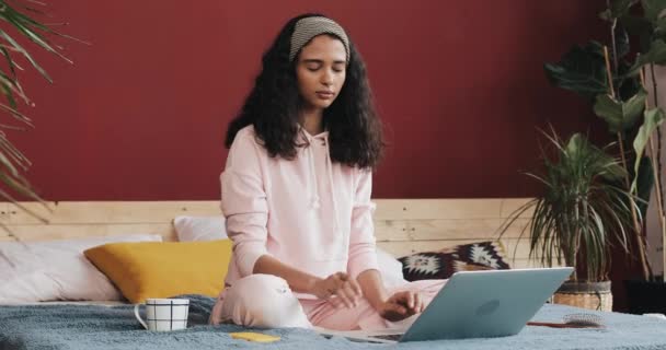 美丽的年轻非洲裔美国妇女做瑜伽练习和观看笔记本电脑上的教程课在家里 — 图库视频影像