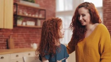 Bir anne ve kızı sıcak mutfağa paskalya yumurtası boyuyor. Gülüyorlar ve eğleniyorlar. Mutlu aile Paskalya için hazırlanıyor. Mutlu Paskalyalar