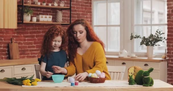 Η μαμά και η κόρη της ετοιμάζονται για το Πάσχα. Ευτυχισμένη οικογένεια προετοιμασία ζωγραφική πασχαλινά αυγά σε ζεστή κουζίνα — Αρχείο Βίντεο