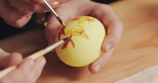 Primer plano de las manos madre e hija colorear huevos de Pascua con colores y cepillo. Huevos coloridos de Pascua. Preparación de la Pascua — Vídeo de stock