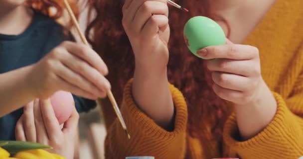 Close up of mother and daughter hands coloring easter eggs with colors and brush. Colorful easter eggs. Preparation of the Easter — Stock Video