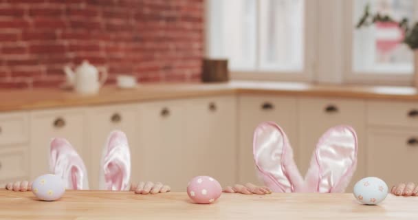 Καλό Πάσχα. Νεαρή μητέρα και κόρη να αρχίσουν να κυνηγούν για πασχαλινά αυγά φορώντας αυτιών λαγουδάκι. Ευτυχισμένη οικογένεια στην προετοιμασία για το Πάσχα στη ζεστή κουζίνα — Αρχείο Βίντεο