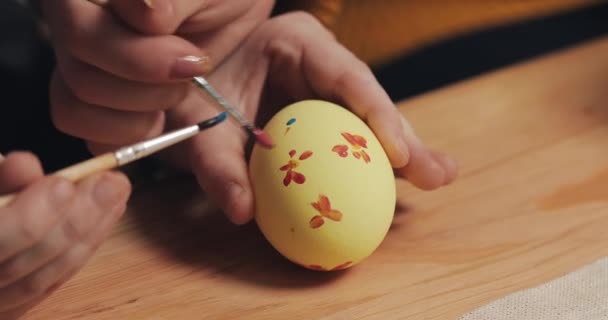 Primer plano de las manos madre e hija colorear huevos de Pascua con colores y cepillo. Huevos coloridos de Pascua. Preparación de la Pascua — Vídeos de Stock