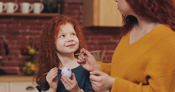 Mutlu paskalyalar. Anne kızı yumurta boyama öğretir. Mutlu bir aile Paskalya için hazırlanıyor. Onlar tavşan kulakları giyiyor