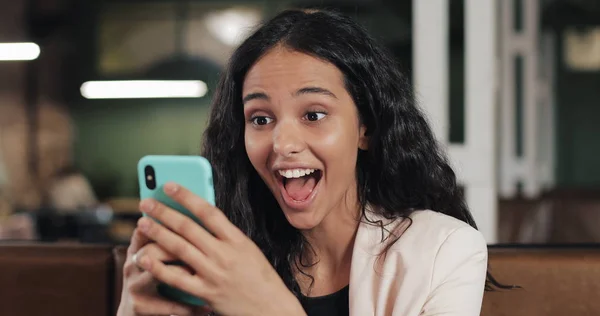 Modern ofisinde oturan Smartphone cep telefonu ile App kullanarak iş kadını. İyi haber smartphone sahip pembe elbiseli güzel casual kadın profesyonel