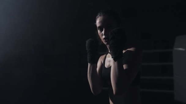 Жіночий боксерський кулак крупним планом - боксер вдаряє в бік відеокамери. Відео бокс для глядачів. Жінка вражає суперника. Повільний рух — стокове відео