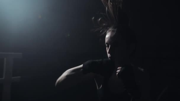 Vrouwelijke bokser die traint in de donkere ring. Slow-motion. Silhouet. Boksen concept — Stockvideo