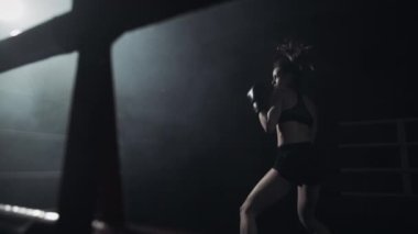 Karanlık ringde eğitim kadın boksör. Ağır çekim. Siluet. Boks konsepti