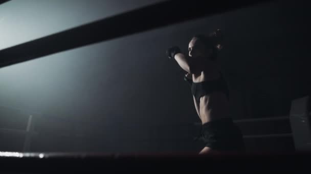 Entraînement de boxeuse dans l'anneau noir. Au ralenti. Silhouette. Concept de boxe — Video