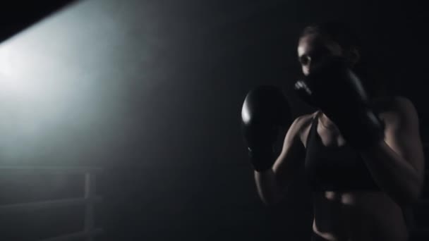 Boxeadora entrenando en el anillo oscuro. En cámara lenta. Silueta. Concepto de boxeo — Vídeos de Stock