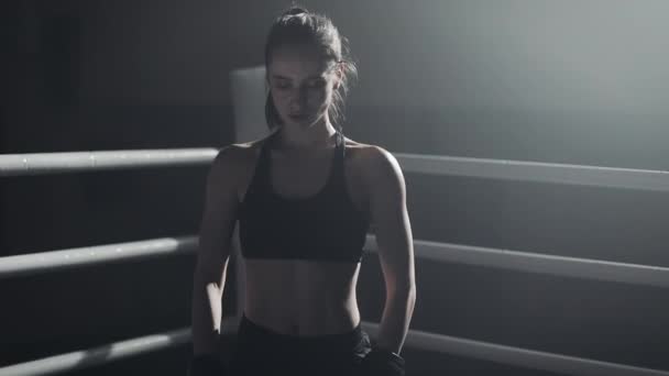 Portrait of tired female boxer standing on the boxing ring and looking intensely at the camera — Stock Video