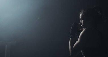 Karanlık ringde eğitim kadın boksör. Ağır çekim. Siluet. Boks konsepti