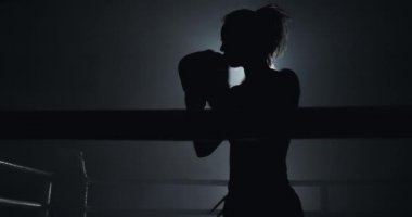 Karanlık ringde eğitim kadın boksör. Ağır çekim. Siluet. Boks konsepti