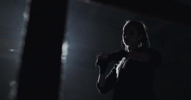 Siyah boks ile el sarma genç kadın karanlık halka sarar. Siluet. Boks konsepti