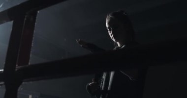 Siyah boks ile el sarma genç kadın karanlık halka sarar. Siluet. Boks konsepti