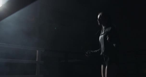 Young woman jumping rope in a dark ring. Silhouette. Boxing concept — Stock Video