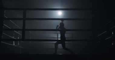 Karanlık ringde eğitim kadın boksör. Ağır çekim. Siluet. Boks konsepti