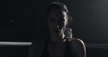 Boks yüzük ayakta yorgun kadın boksör portre ve yoğun kamera bakıyor