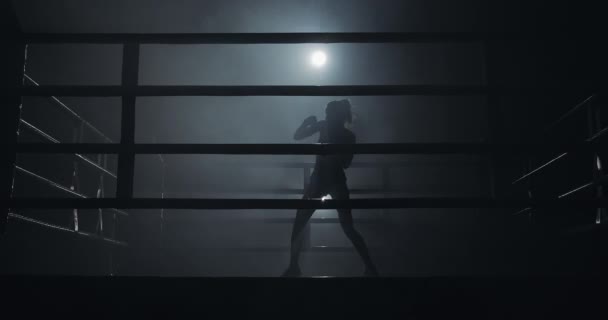 女性ボクサーの暗いリングのトレーニングします。スローモーション。シルエット。ボクシングのコンセプト — ストック動画