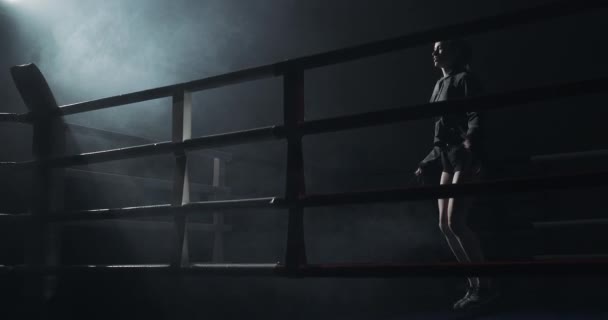 Junge Frau beim Seilspringen in einem dunklen Ring. Silhouette. Boxkonzept — Stockvideo