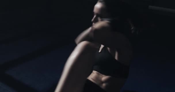 Young woman doing abdominal exercise in the boxing ring. Girl training, silhouette — Stock Video