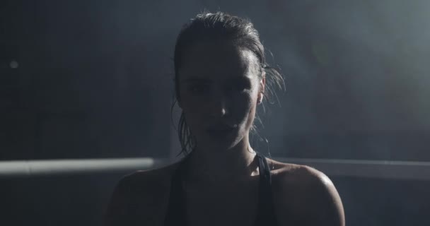 Retrato de una mujer boxeadora cansada parada en el ring de boxeo y mirando intensamente a la cámara — Vídeos de Stock