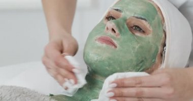 Güzellik güzel genç kız Spa prosedürleri yok. Kadın yeşil yüz maskesini yıkamış.