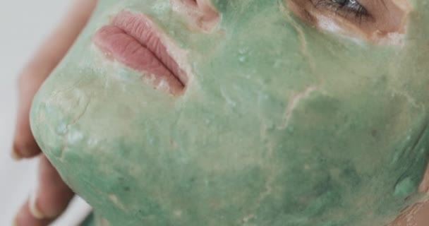 美容師で美しい若い女の子は、スパの手順を行います。及ぼしの手は、患者の顔に緑色のマスクを適用します。ボディケア健康ライフスタイルのコンセプト — ストック動画