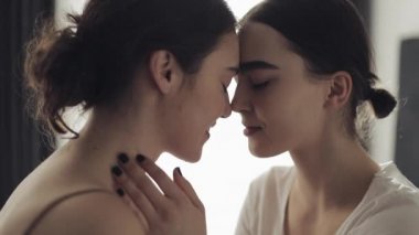 Mutlu lezbiyen çift kucaklayan her diğer ve Smiling at ev yüz için yüz içinde yavaş hareket