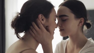Mutlu lezbiyen çift kucaklayan her diğer ve Smiling at ev yüz için yüz içinde yavaş hareket