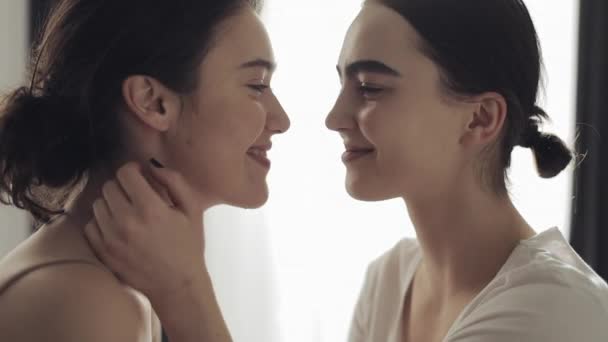 Feliz pareja de lesbianas abrazándose y sonriendo en casa cara a cara en cámara lenta — Vídeos de Stock