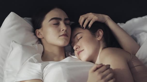 Lesbisk par som omfamnar i sängen hemma. Slow motion. Livsstil, HBT-konceptet — Stockvideo
