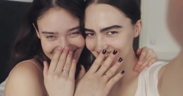 Feliz pareja lesbiana de vídeo chat en el teléfono inteligente. Muestran anillos de compromiso disfrutando de una celebración romántica. LGBT lesbianas pareja juntos . — Vídeo de stock