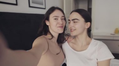 Mutlu lezbiyen çift evde selfie fotoğrafı çekiyor. İnsanlar, romantik ilişki konsepti. Yavaş çekim.