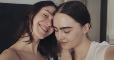 Mutlu lezbiyen çift evde selfie fotoğrafı çekiyor. İnsanlar, romantik ilişki konsepti. Yavaş çekim.