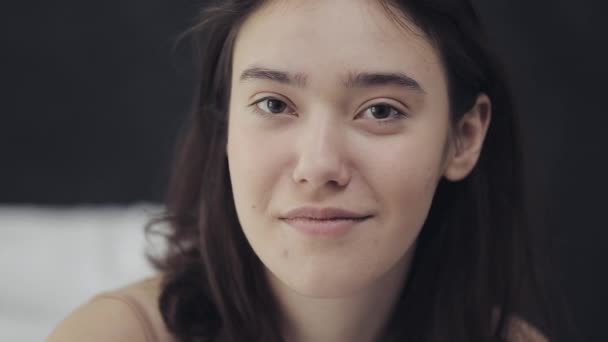 Portrait of a young lesbian woman sitting on the bed and looking at camera. — Stock Video