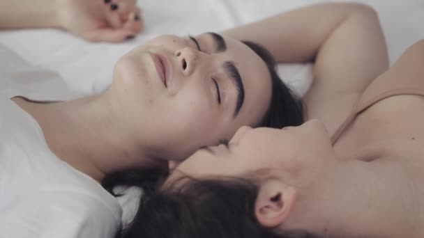 Lyckliga lesbiska tjejer ligger på sängen och ler och njuter av varandra. HBT-familjens koncept, slow motion. — Stockvideo