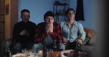 Evde televizyonda futbol maçı izleyen üç arkadaş, takım hayal kırıklığına uğradı.