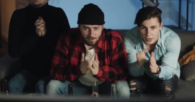 Üç arkadaş evde televizyonda futbol maçı izlerken, en iyi futbol takımı tezahürat. Duygu. Mens taraftarları galibiyeti kutluyor.