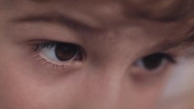 Küçük çocuk ilgi ile modern sarı akıllı telefon karikatür izlerken yatakta yatan.