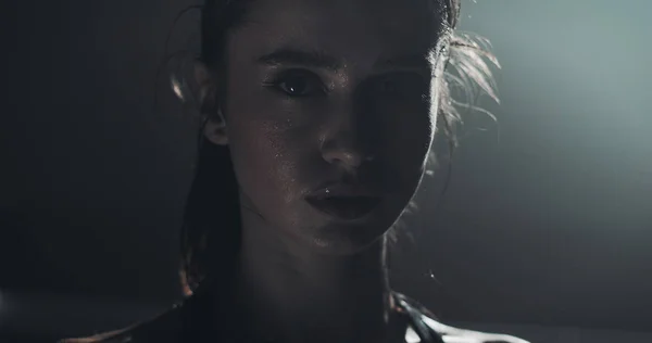 Boks halka üzerinde duran ve kameraya bakarak yorgun kadın boksör portresi