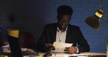 Stresli işadamı, gece ofisinde masa başında çalışan belgelerde yanlışlıkla kafası karışmış. İşkolik, son tarih kavramı.