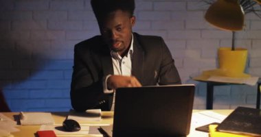 Yorgun ve stresli işadamı baş ağrısı ile ofisinde geç saatlere kadar çalışıyor. Geceleri dizüstü bilgisayarı üzerinde çok çalışıyor. Ofis çalışanı, serbest çalışan. Işkolik.