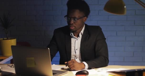 Portrait d'un homme d'affaires fatigué travaillant dans un bureau moderne et regardant dans la caméra. Temps de nuit . — Video