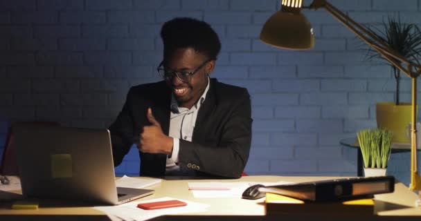 Heureux jeune homme d'affaires travaillant au bureau de nuit. Il célèbre le succès, bonnes nouvelles sur le web . — Video