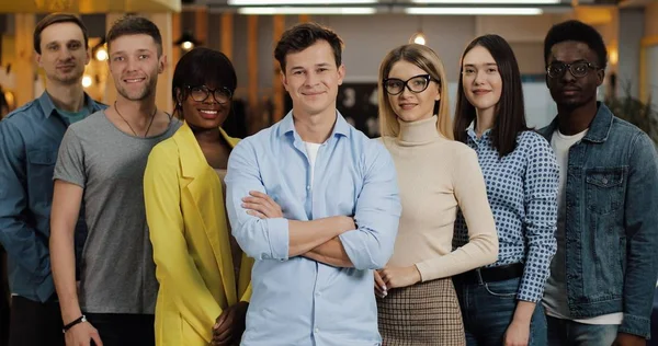 Gülümseyen ve kameraya bakan genç iş adamlarının portresi. Kavramı: uluslararasılık, başlangıç, kariyer, başarı iş, takım.