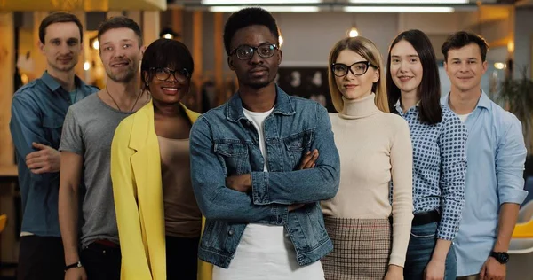 Gülümseyen ve kameraya bakan genç iş adamlarının portresi. Kavramı: uluslararasılık, başlangıç, kariyer, başarı iş, takım.